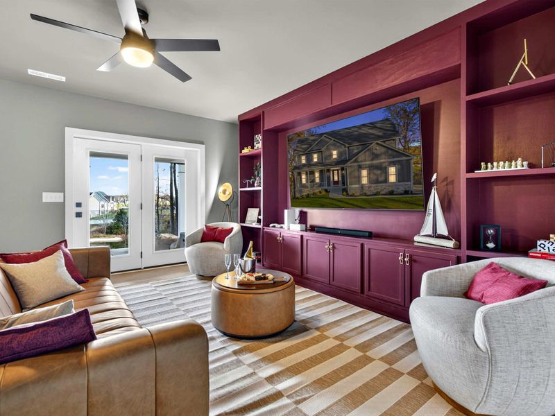 Lower Lounge Full View - Leather sofa, swivel chairs, the bold entertainment wall, and French doors to the patio with lake views.