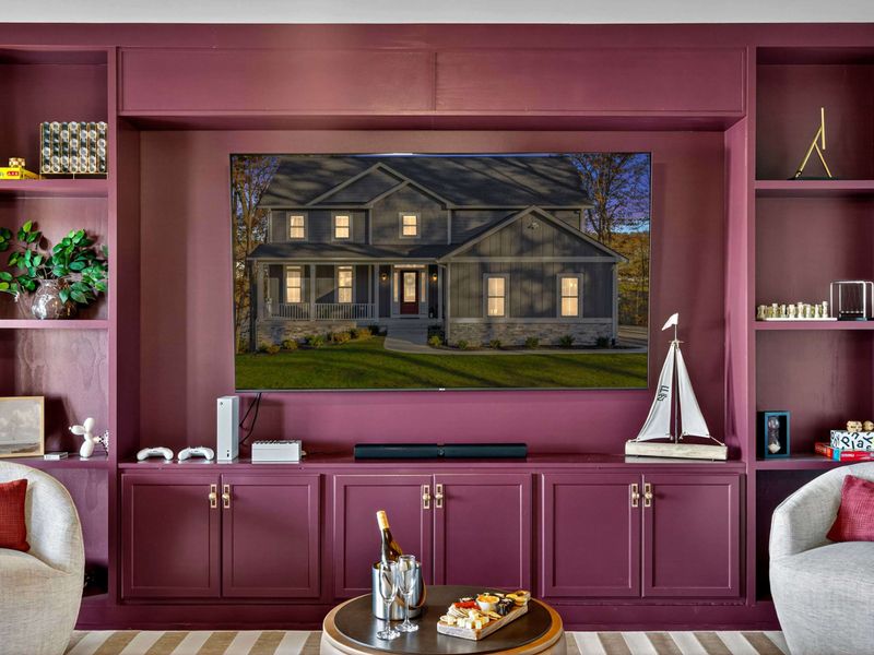 Entertainment Wall Close-Up - The plum built-in with a big-screen TV, soundbar, Xbox, and a model sailboat on the shelf.