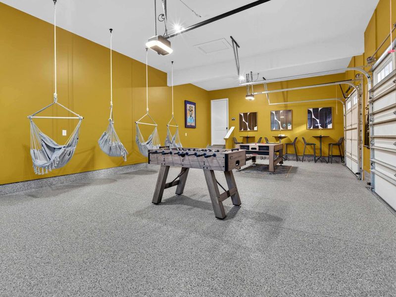 Foosball and Hammocks - A rustic foosball table and four hanging hammock chairs against the mustard yellow walls.
