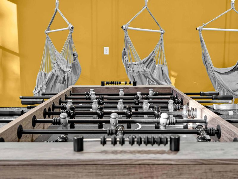Foosball Close-Up - The wooden foosball table with hammock chairs swaying in the background.