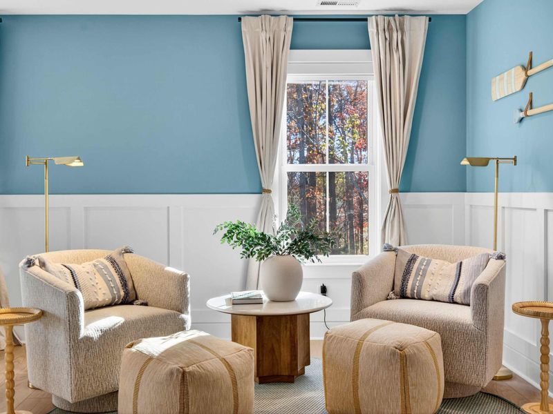 Primary Reading Nook - Two upholstered swivel chairs, brass reading lamps, and decorative oars create a quiet corner in the primary suite.