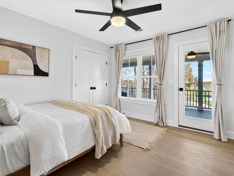 Main Level Bedroom - A queen bed with deck access through a glass door, modern art, and clean neutral tones.