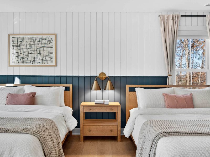 Double Queen Bedroom - Side-by-side queens with a shared nightstand and warm brass lighting, ideal for groups traveling together.