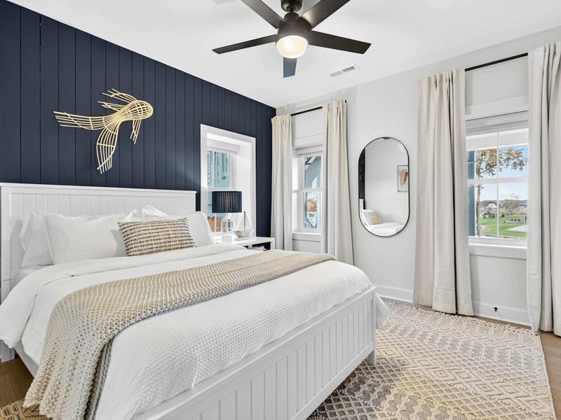 Queen Bedroom - Natural light pours through the windows while lake views and a full-length mirror complete the space.