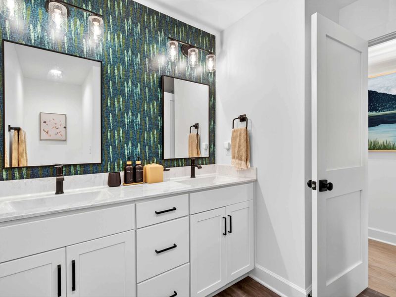 Shared Bath - A double vanity with teal wallpaper, dual mirrors, and clean finishes keeps the morning routine easy.