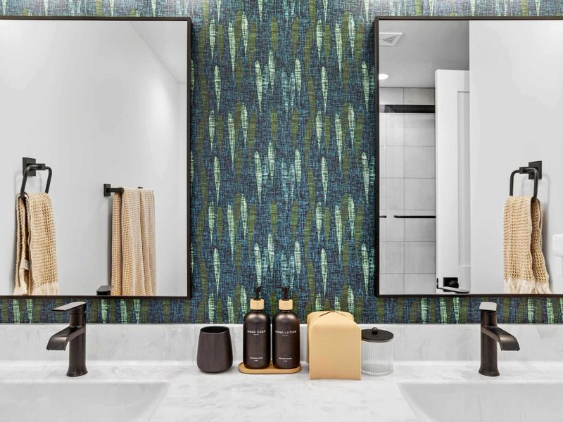 Vanity Detail - Teal raindrop wallpaper and matte black fixtures bring personality to this shared bath vanity.
