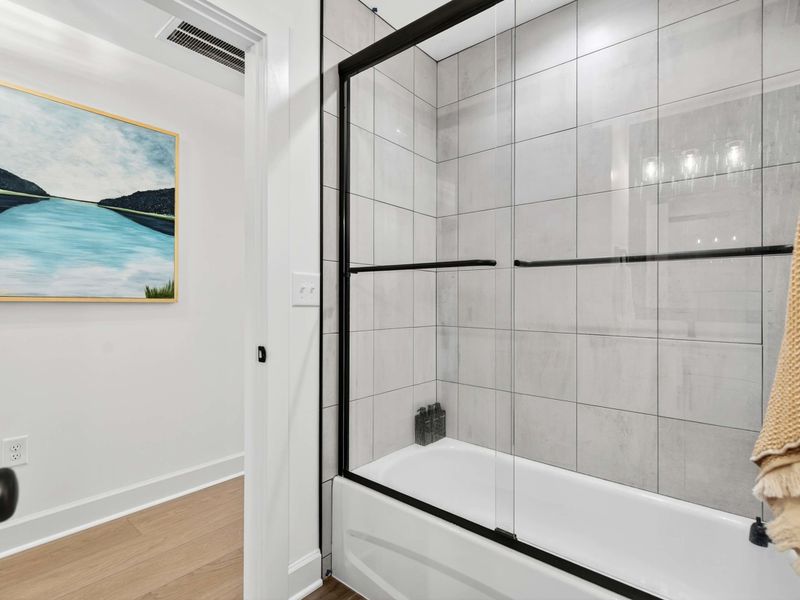 Shower Detail - Oversized gray tile and a glass enclosure give this tub-shower combo a clean, modern look.