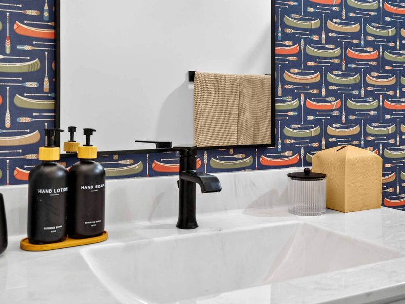 Vanity Detail - Black fixtures and canoe wallpaper add playful character alongside curated bath amenities.
