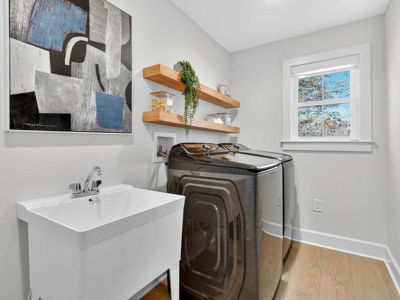 Laundry Room - A full-size washer, dryer, and utility sink with floating shelves keep lake-day laundry simple.