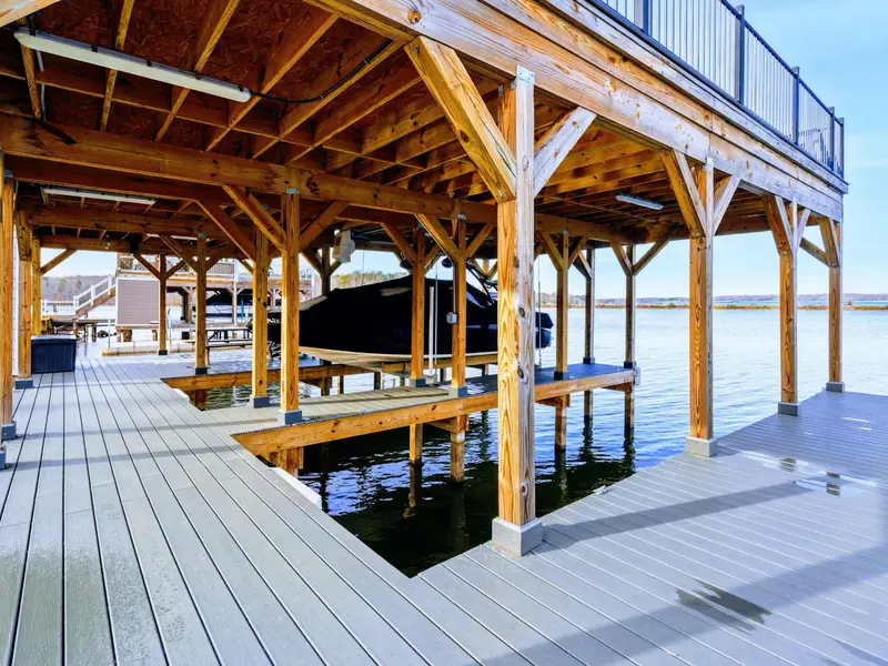 Lower Patio Seating - Cushioned chairs and a dining table under the wood-beamed covered patio, just steps from the lake.