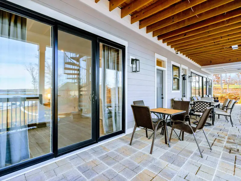 Dining Table - From the head of the table, lake views through the sliding glass doors and the open kitchen beyond set the scene for memorable meals.