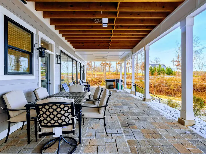 Dining and Kitchen - A large farmhouse table seats the whole group under vaulted ceilings with exposed wood beams and designer lighting.