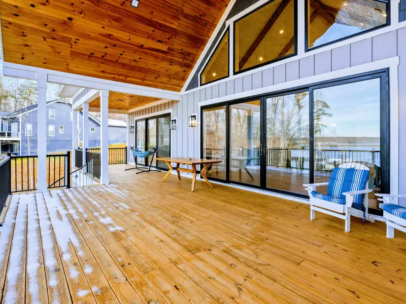 Kitchen Overview - The full kitchen stretches beneath the vaulted wood-beamed ceiling, with the dining table and lake views just steps away.