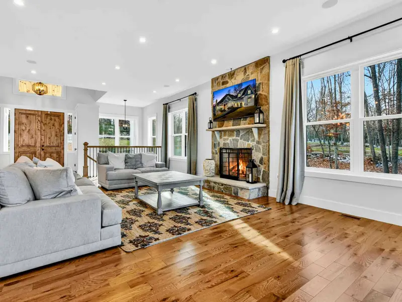 Lower Living Room - A plush sectional and stone fireplace create a cozy second gathering space on the lower level.