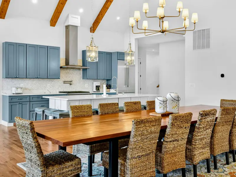 Lower Kitchen - A second full kitchen on the lower level features quartz counters, bistro stools, gold pendants, and open wood shelving.