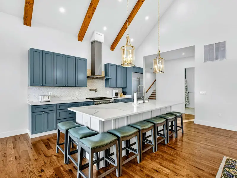 Lower Kitchen Detail - Brass faucet, quartz island, and open shelving give this lower-level kitchen a boutique feel.