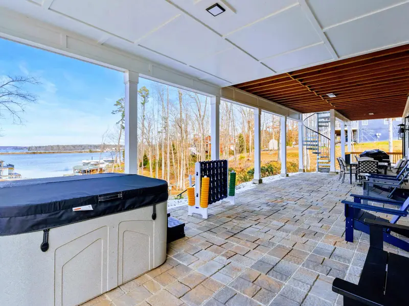 Sunroom - Wicker seating and a sea turtle rug fill this bright, window-lined room with panoramic lake and neighborhood views.