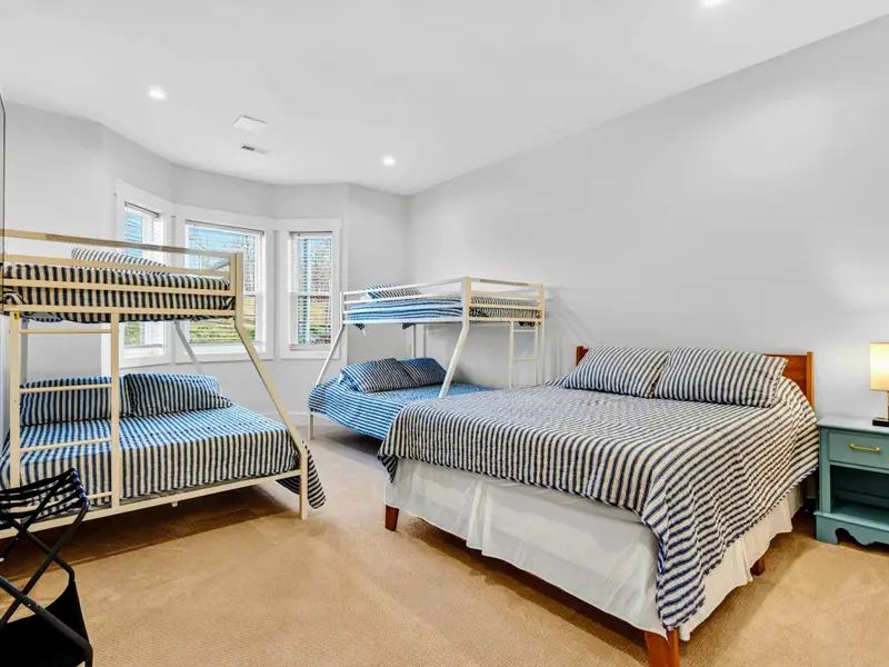 Bunk Room - Striped bedding on a queen bed and two twin-over-full bunks gives this lower-level room plenty of sleeping options.
