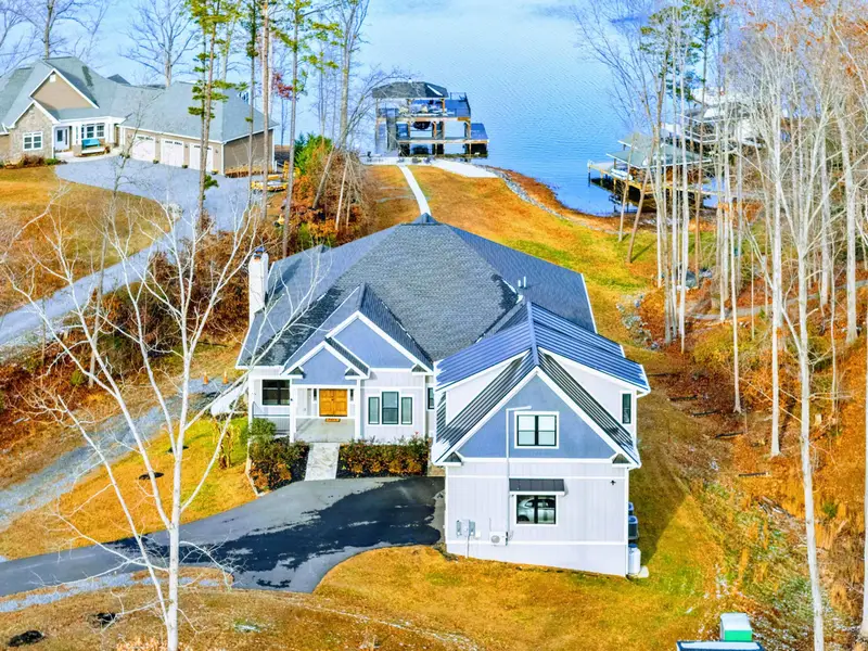 Aerial - A bird's-eye view of the estate, covered dock, and waterfront lot from directly above.
