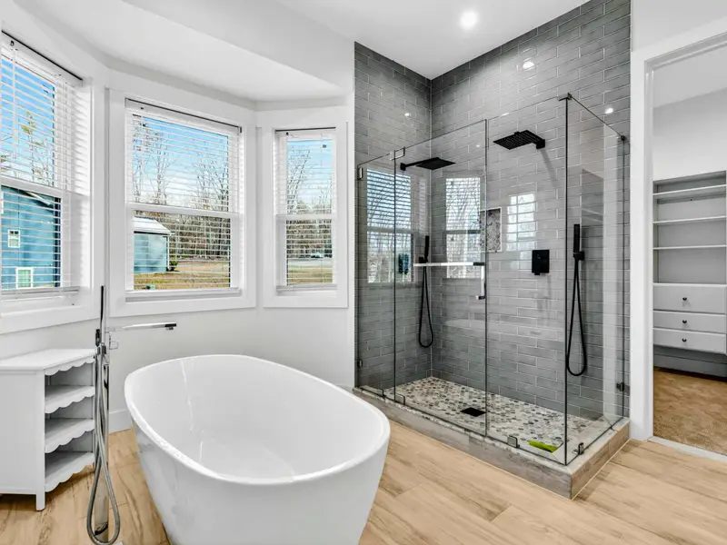 Shower Detail - Glossy black subway tile and a glass enclosure line the walk-in shower in the lower-level bath.
