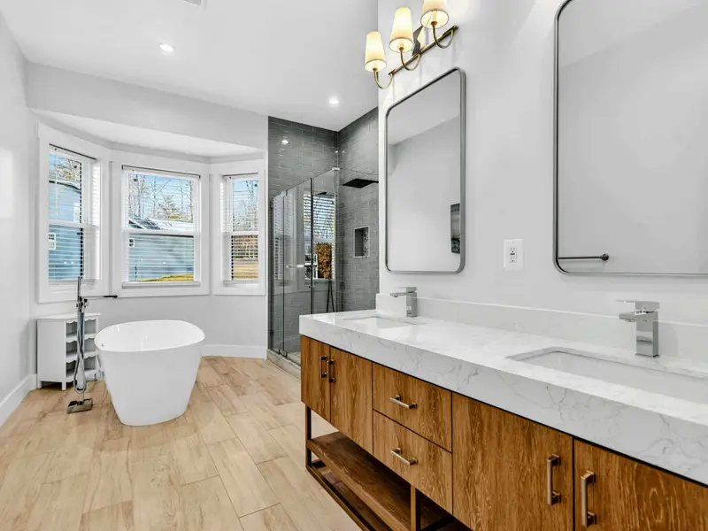 Lower Bath 1 - The double vanity, framed mirrors, and doorway to the tiled shower room give this bathroom a boutique hotel feel.
