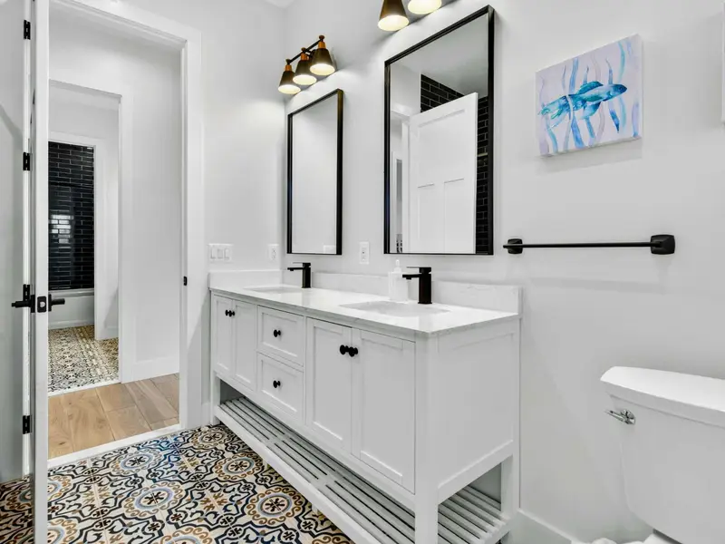 Lower Bath - Another angle of the double vanity, with coastal wall art and the patterned tile floor adding character.