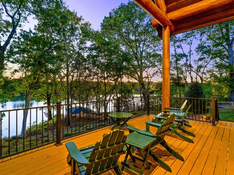 Deck - Green Adirondack chairs face the sunset-lit lake for a peaceful end to the day.