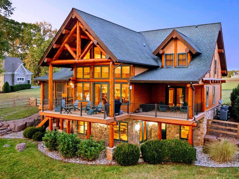 Exterior - Lake-side view reveals multiple levels, stone accents, timber framing, and decorative rock landscaping.
