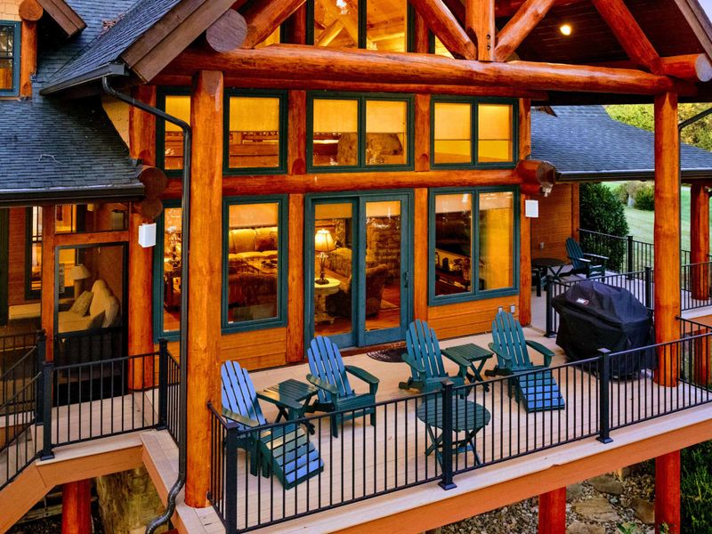 Upper Deck - Adirondack chairs and a gas grill under the timber frame roof create the perfect outdoor entertaining space with lake views.