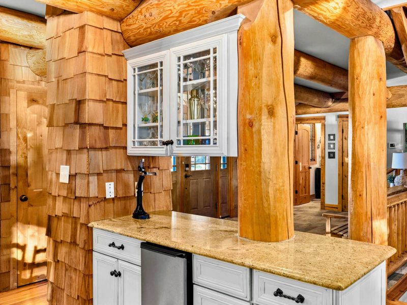 Kitchen - Cedar shake accent wall and a pass-through bar with granite countertop and glass-front cabinets add rustic charm.