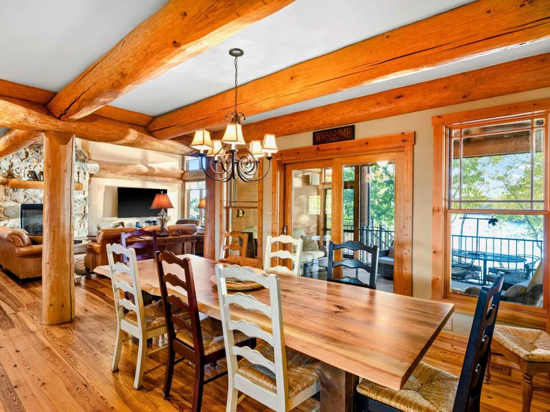 Dining Room - The farmhouse table connects the great room and kitchen with log beams framing the open layout.