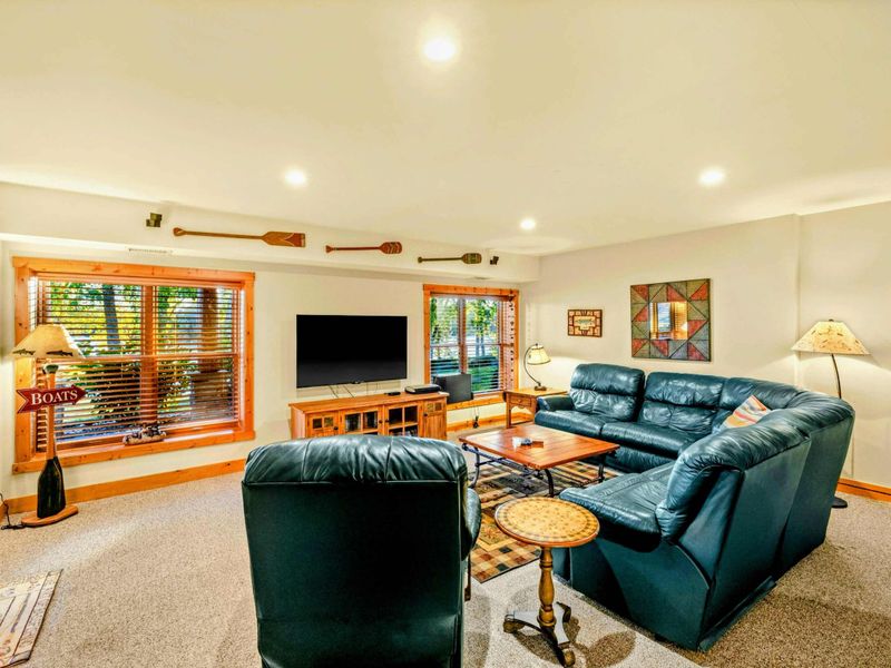 Lower Level Family Room - Comfortable leather seating with oar wall art, quilted accents, and warm lighting for movie nights.