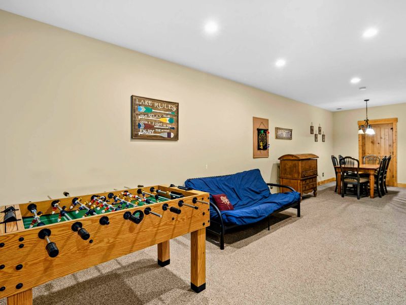 Game Room - Foosball table, blue futon, small dining table, and a 'Lake Rules' sign make this the go-to hangout spot.
