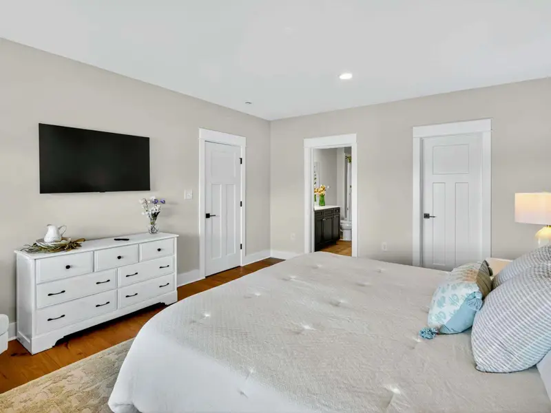 Lower Level King Suite - Another angle showing the Smart TV, dresser, walk-in closet, and large en-suite bath entry.