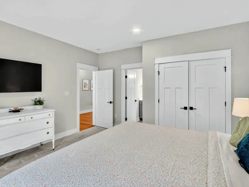 Main Level King Suite -Another view of the suite highlights the Smart TV, antique dresser, spacious closet, and private doorway leading to the beautifully appointed en-suite bath.