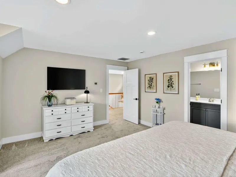 Upper King Suite - Smart TV, dresser, hallway entry, and en-suite bath with a navy blue vanity and antique dresser and luxury bedding.  Guests love how our king bedrooms have their own full baths! What a way to vacation! All new furnishings!