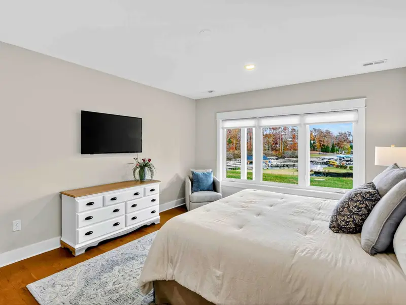Lower Level King Suite - A Smart TV, two-tone dresser, accent chair, and wide picture windows with marina and lake views in this lower-level king retreat.