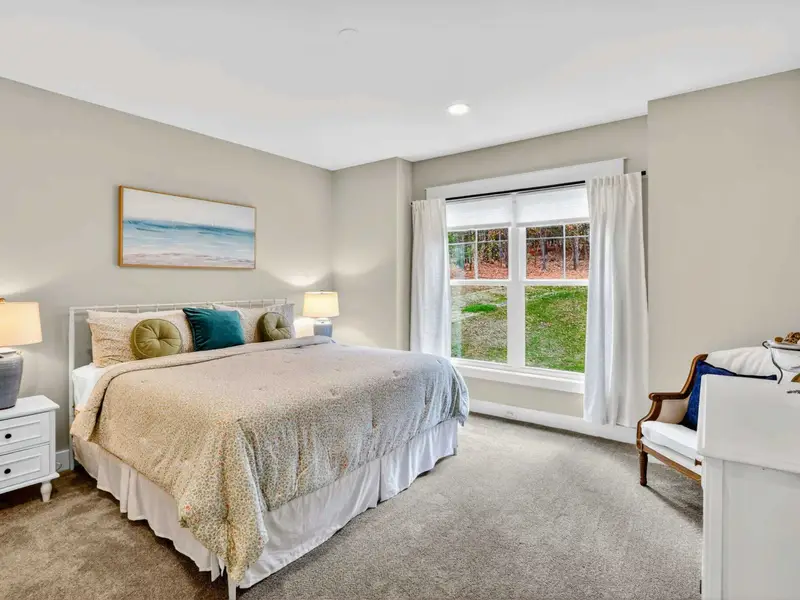 Main Level King Suite - A king bed with ocean artwork, a Smart TV, and garden views through the window in this quiet lower-level retreat.