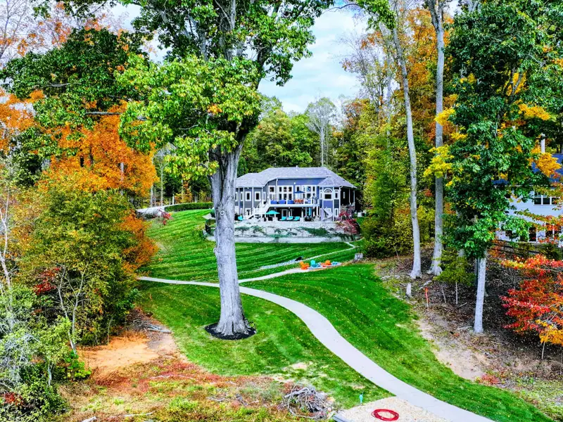 Professionally manicured lawn with dramatic stripes, sculpted gardens, and curated pathways.