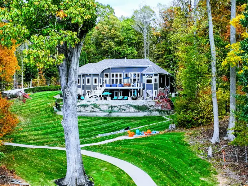 Professionally manicured lawn with dramatic stripes, sculpted gardens, and curated pathways.