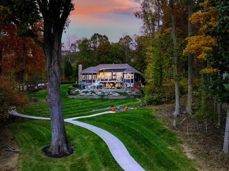Professionally manicured lawn with dramatic stripes, sculpted gardens, and curated pathways.