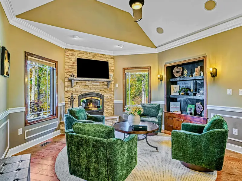 The Green Room is a cozy second living space with deep green swivel chairs, warm textures, and views of the trees—perfect for chatting with the chef, curling up by the fireplace, or lingering over games, wine, and conversation.