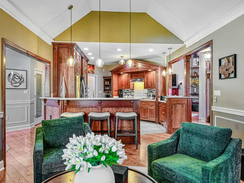 The Green Room is a cozy second living space with deep green swivel chairs, warm textures, and views of the trees—perfect for chatting with the chef, curling up by the fireplace, or lingering over games, wine, and conversation.