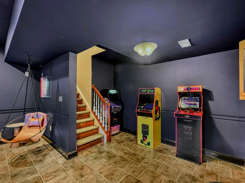 The Billiard & Games Lounge is a lower-level play hub with a convertible pool/ping-pong/dining table, darts, arcade and wall games, leather swings, and direct patio access—designed for laughter, competition, and all-ages fun.