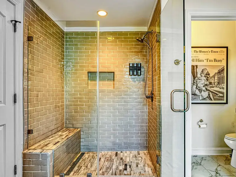 The Primary Ensuite is a spa-like retreat featuring a soaking tub with lake views, arched windows, and an oversized walk-in shower with dual heads and bench—designed for quiet mornings, slow evenings, and total relaxation.