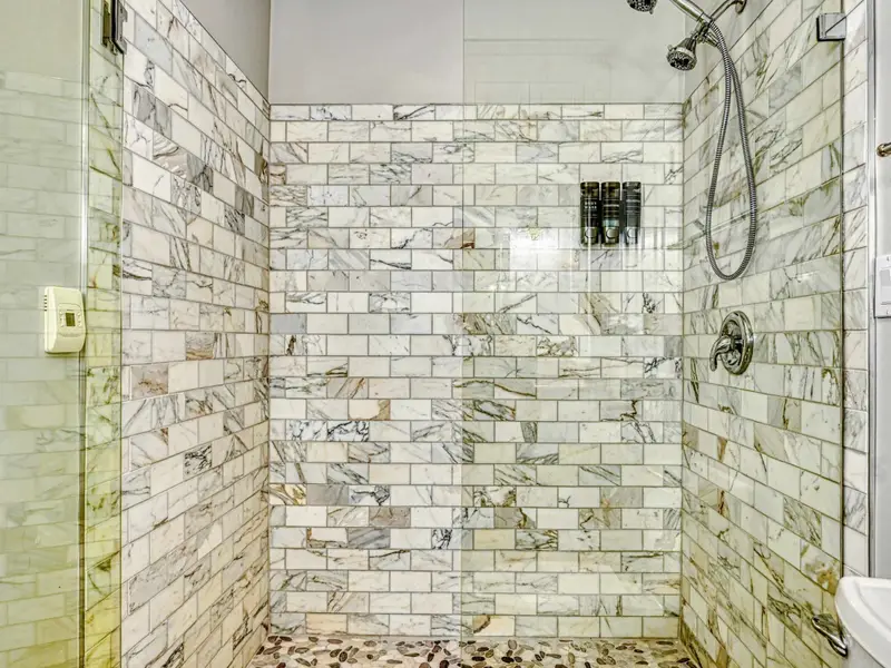 The Junior Primary Ensuite is a chic, spa-like bath with marble tile, refined lighting, and a fully tiled walk-in shower with excellent water pressure—bringing boutique-hotel elegance and quiet luxury to this private retreat.