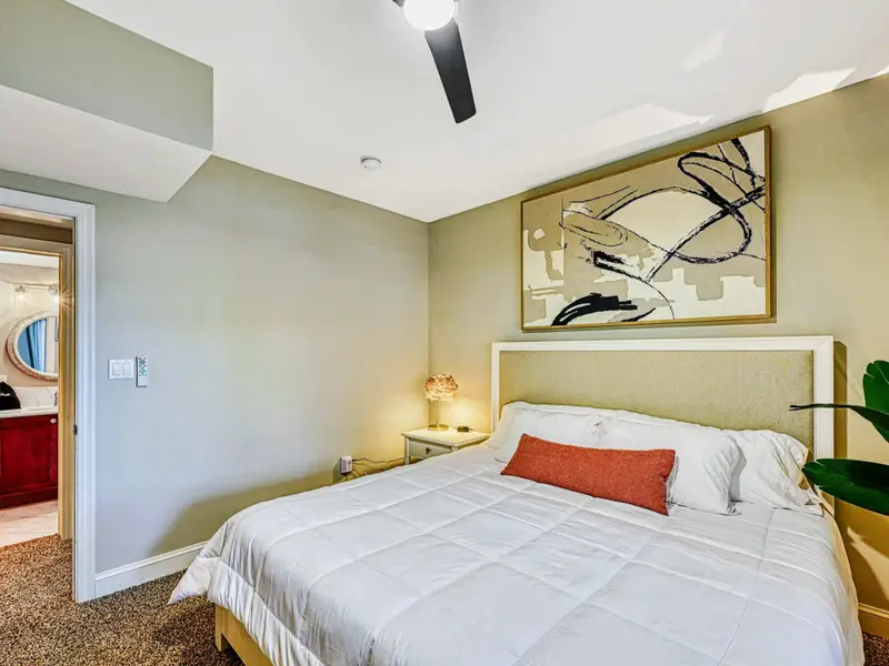 King Suite: Warm, serene retreat with king bed, hotel-quality linens, smart TV, bedside charging, soft lighting & greenery, plus access to a shared hall bathroom.