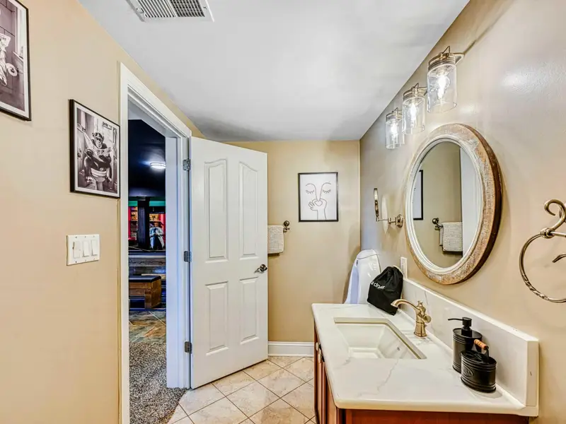 Walk-in glass shower, marble-style vanity, stocked dispensers, bright lighting, ample storage, and a convenient urinal—designed for comfort and ease just outside the bedrooms.