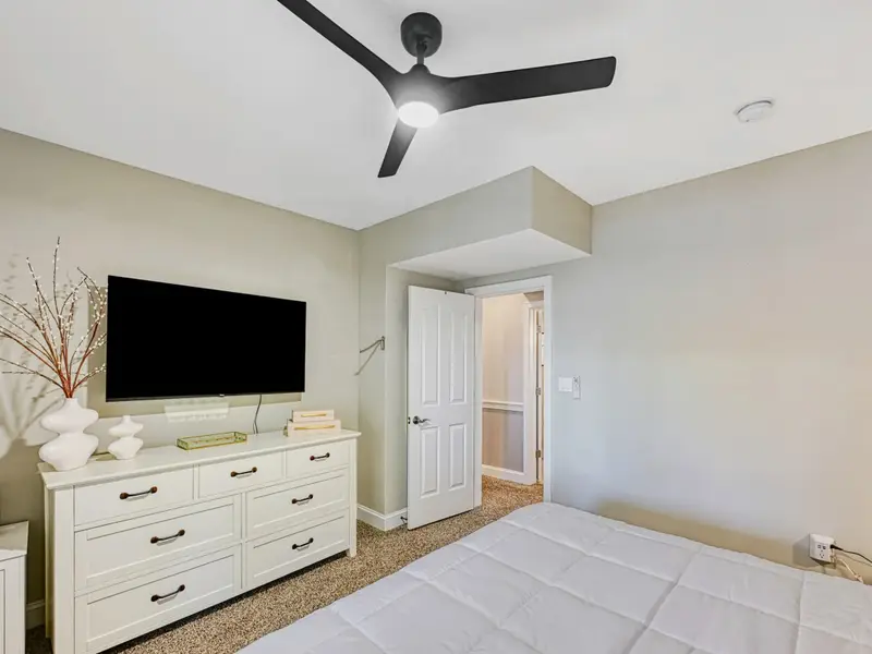 King Suite: Warm, serene retreat with king bed, hotel-quality linens, smart TV, bedside charging, soft lighting & greenery, plus access to a shared hall bathroom.