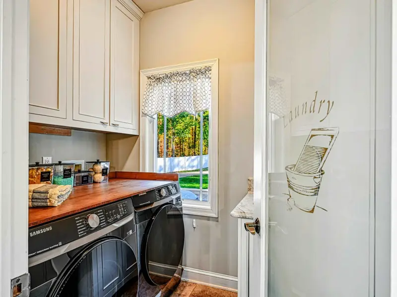 Bright, functional laundry space with full-size washer & dryer, counter for folding, and plenty of storage—making long stays easy and stress-free.